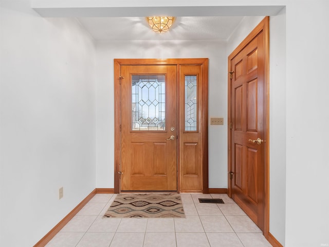 foyer featuring light tile patterned floors and baseboards