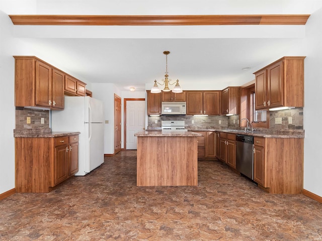 kitchen featuring a sink, backsplash, a center island, white appliances, and baseboards