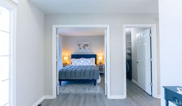 bedroom featuring multiple windows, wood finished floors, and baseboards