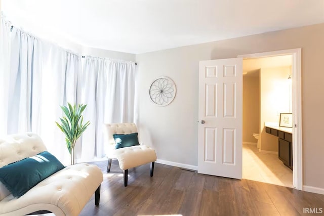 sitting room with baseboards and wood finished floors