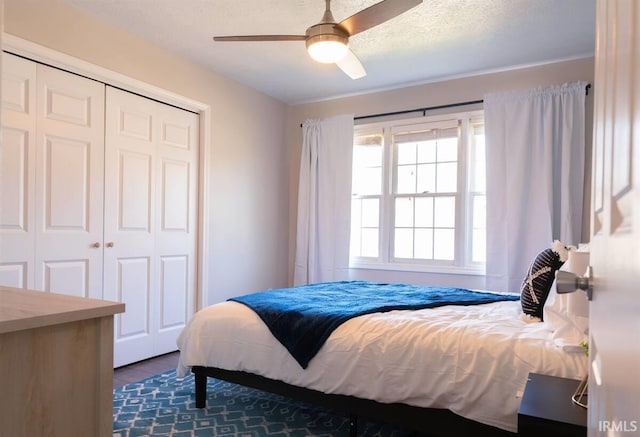 bedroom featuring a textured ceiling, wood finished floors, a closet, and ceiling fan