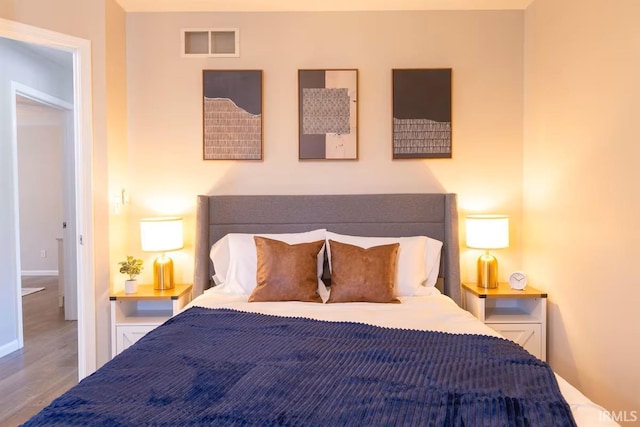 bedroom featuring visible vents and wood finished floors