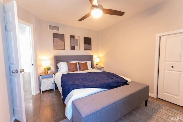 bedroom featuring visible vents, baseboards, ceiling fan, and hardwood / wood-style flooring