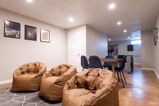 living room featuring recessed lighting, baseboards, and concrete flooring