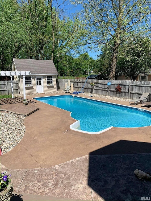 view of pool featuring a fenced in pool, a fenced backyard, an outdoor structure, a storage structure, and a patio area