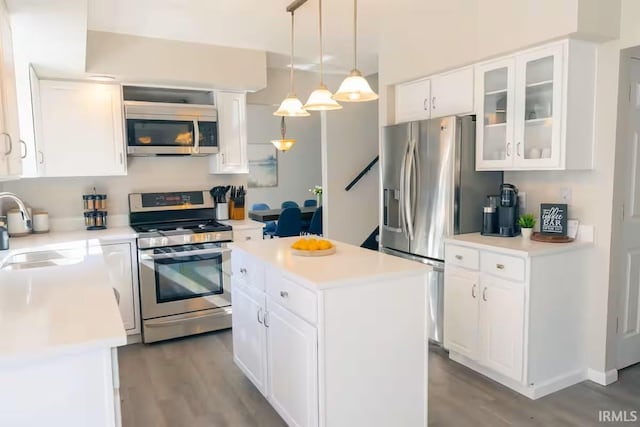 kitchen with a sink, a center island, white cabinetry, and stainless steel appliances