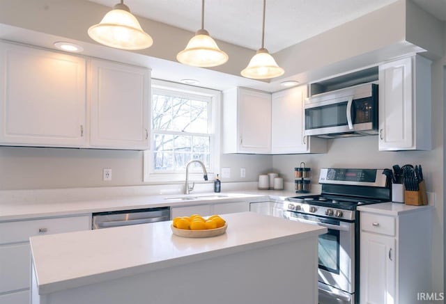 kitchen with a sink, appliances with stainless steel finishes, white cabinets, and light countertops