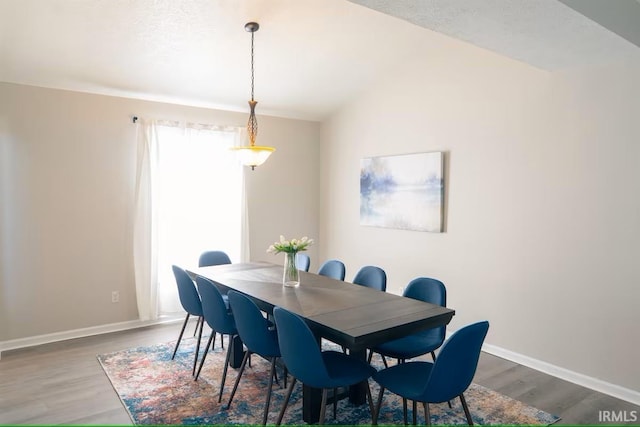 dining room featuring baseboards, lofted ceiling, and wood finished floors