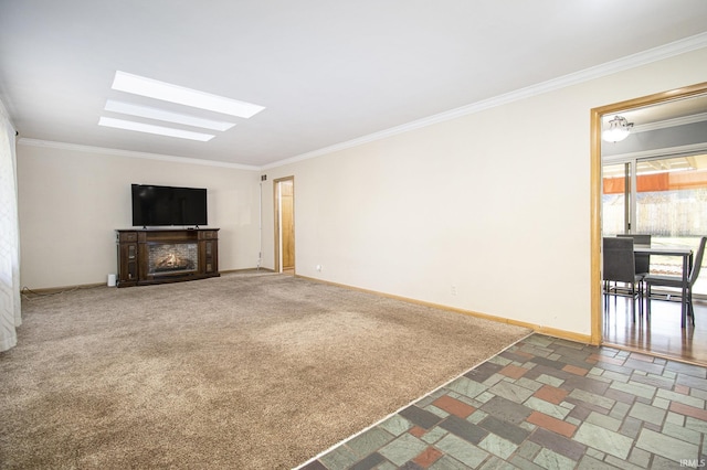 unfurnished living room with baseboards, carpet, ornamental molding, a fireplace, and a skylight