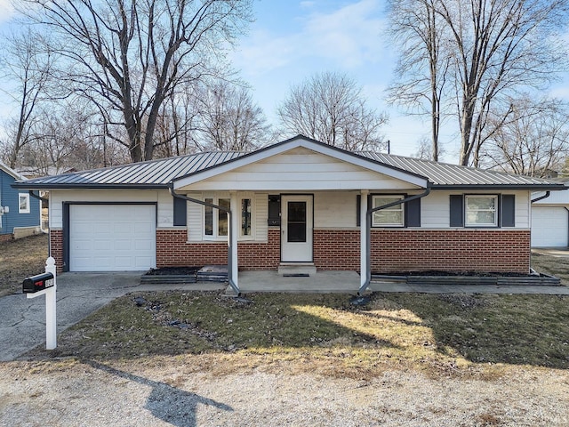 view of front of house with driveway, a porch, metal roof, a garage, and brick siding