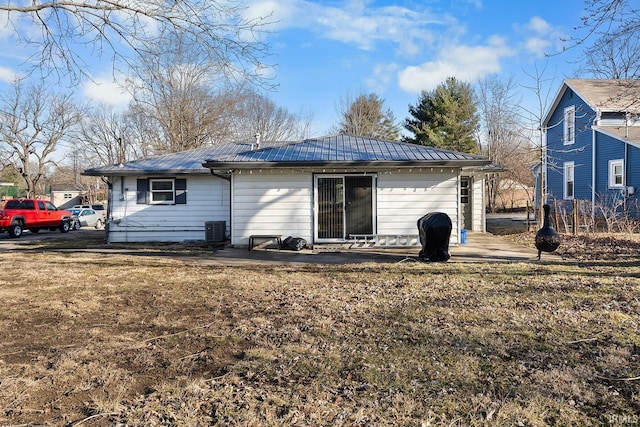 rear view of property with metal roof and central AC