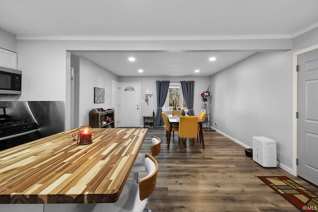 dining space with recessed lighting, baseboards, and dark wood finished floors