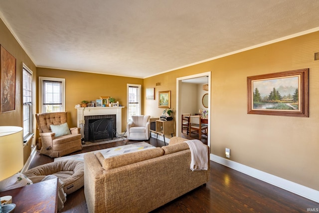 living room with dark wood-style floors, baseboards, ornamental molding, a textured ceiling, and a brick fireplace