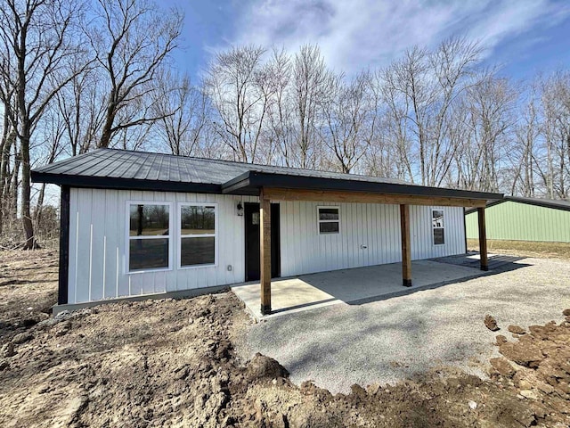 back of property featuring metal roof and a patio