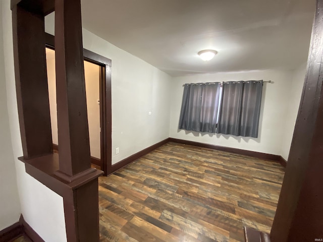 spare room with dark wood-style floors and baseboards