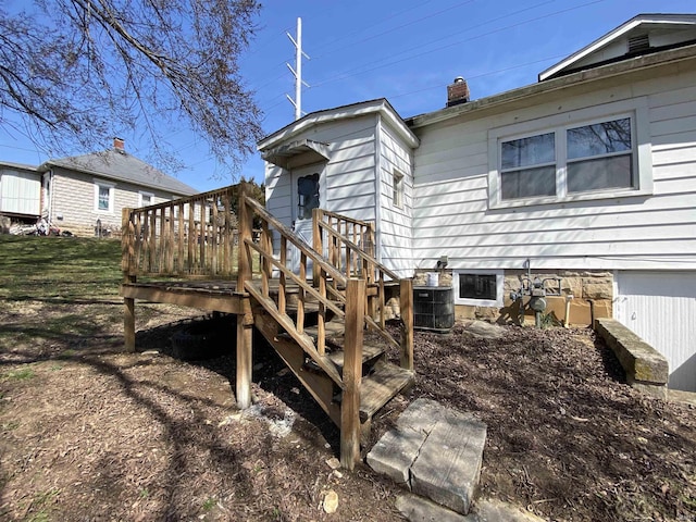 back of property featuring central AC unit, a chimney, and a deck