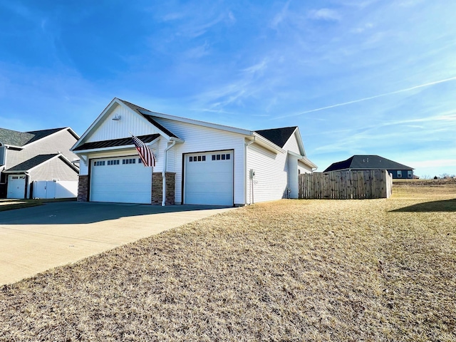 view of front of property featuring fence, metal roof, driveway, an attached garage, and a standing seam roof