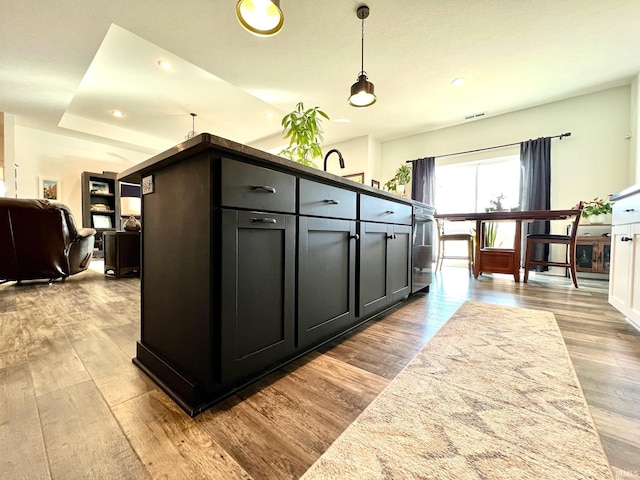 kitchen with visible vents, decorative light fixtures, open floor plan, wood finished floors, and recessed lighting