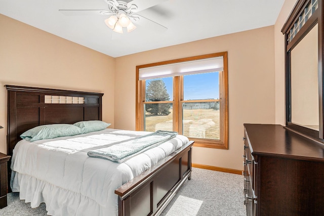 bedroom with ceiling fan, baseboards, and light carpet