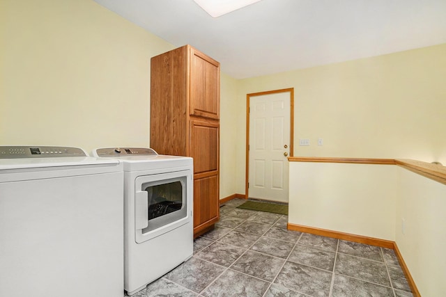 clothes washing area with washer and dryer, baseboards, and cabinet space