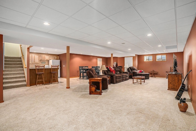 living room with recessed lighting, stairs, a paneled ceiling, light carpet, and a dry bar