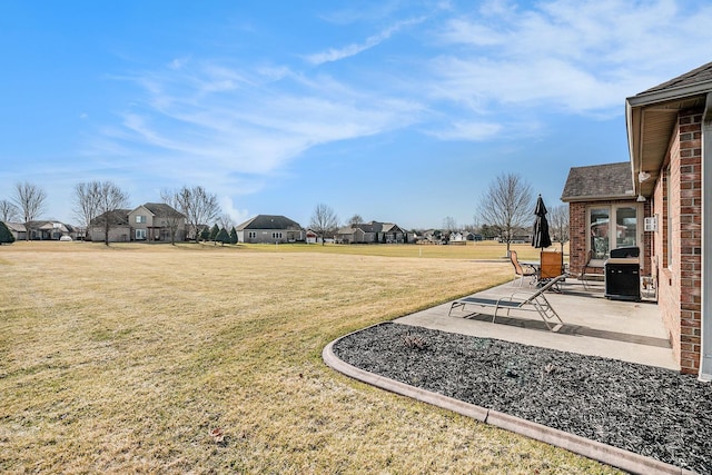 view of yard with a residential view and a patio