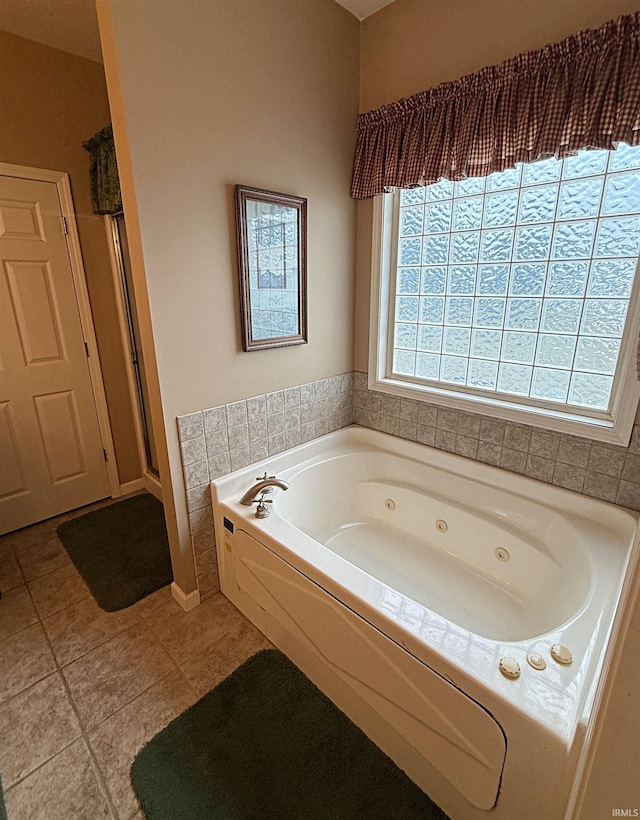 bathroom featuring tile patterned floors, a shower stall, and a jetted tub