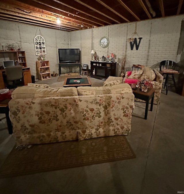 living area with concrete flooring and brick wall