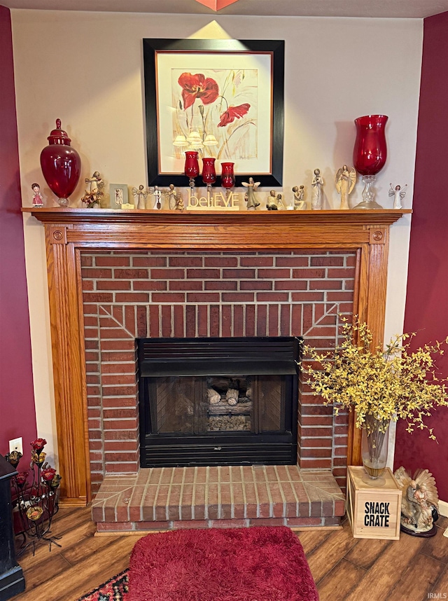 interior details featuring a brick fireplace and wood finished floors