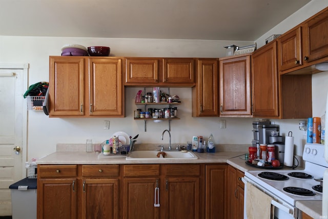 kitchen with white range with electric stovetop, brown cabinets, light countertops, and a sink