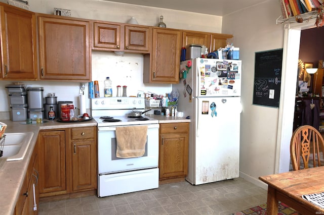 kitchen with brown cabinetry, white appliances, light countertops, and a sink