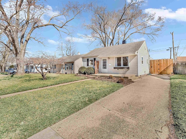 view of front of home featuring driveway, a chimney, a front yard, and fence