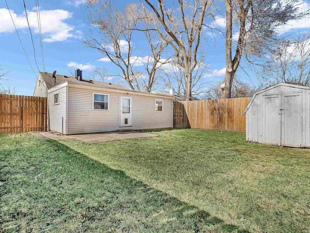 rear view of property featuring a lawn, a storage shed, a fenced backyard, an outbuilding, and a patio