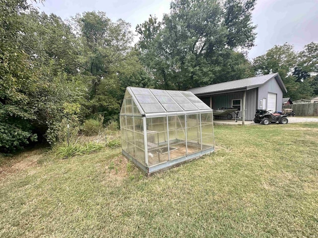 view of yard with an outbuilding, a garage, and an exterior structure