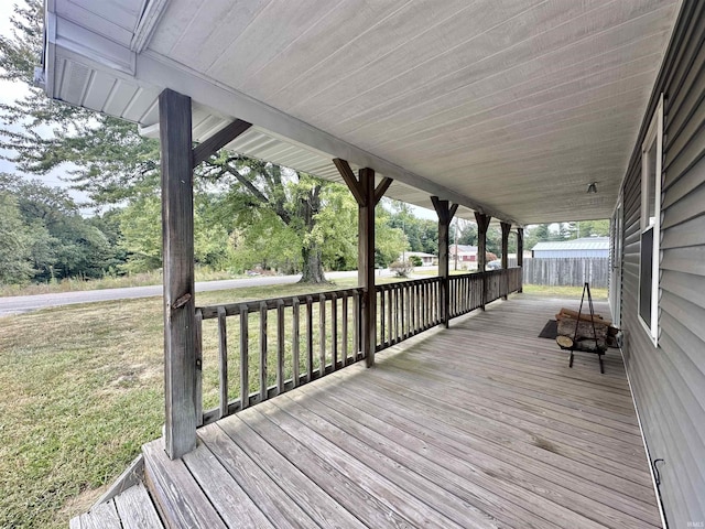 wooden terrace featuring a lawn