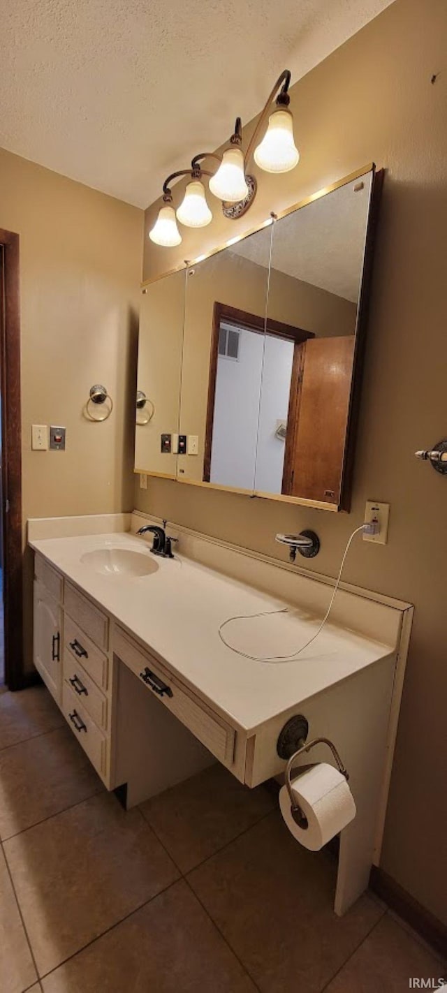 bathroom with tile patterned flooring, visible vents, a textured ceiling, and vanity