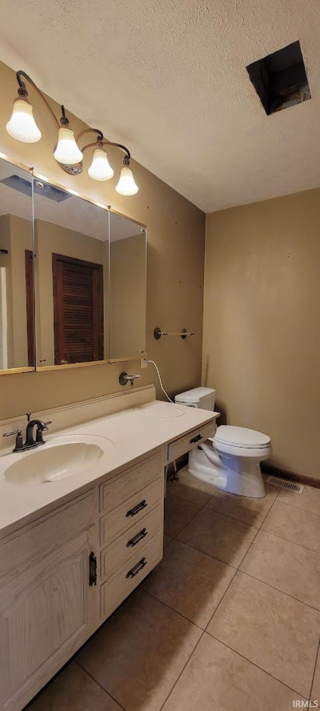 bathroom with vanity, visible vents, tile patterned flooring, a textured ceiling, and toilet