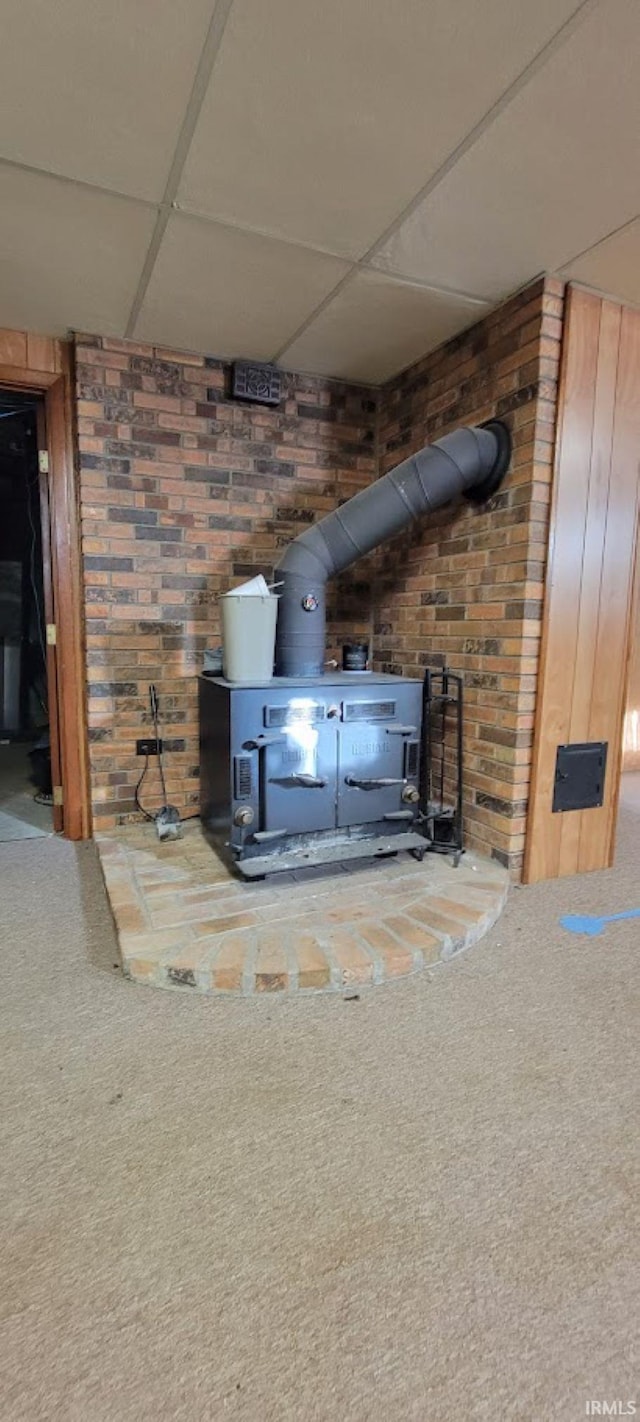 room details featuring a wood stove, wooden walls, and carpet