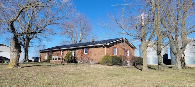 view of front facade featuring brick siding and a front lawn