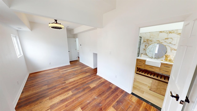 empty room featuring visible vents, wood finished floors, and baseboards