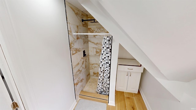 bathroom with a shower stall and wood finished floors