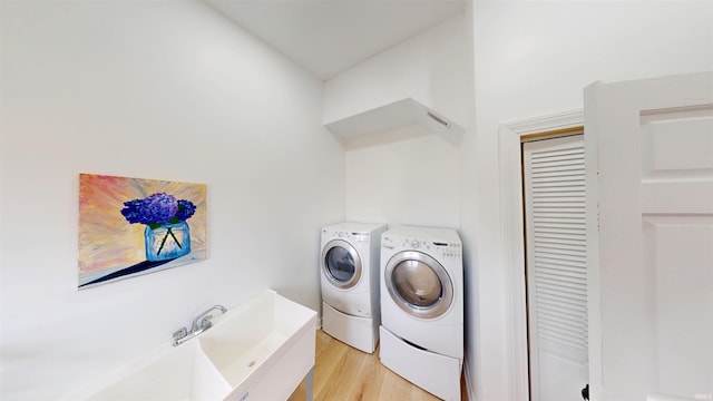 washroom with light wood finished floors, laundry area, and washer and dryer