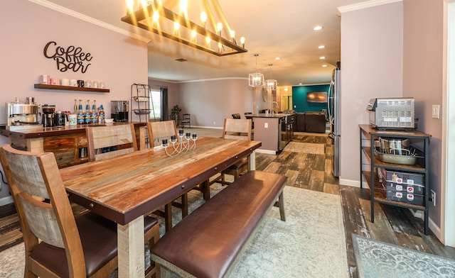 dining room featuring dark wood-type flooring, baseboards, ornamental molding, recessed lighting, and an inviting chandelier