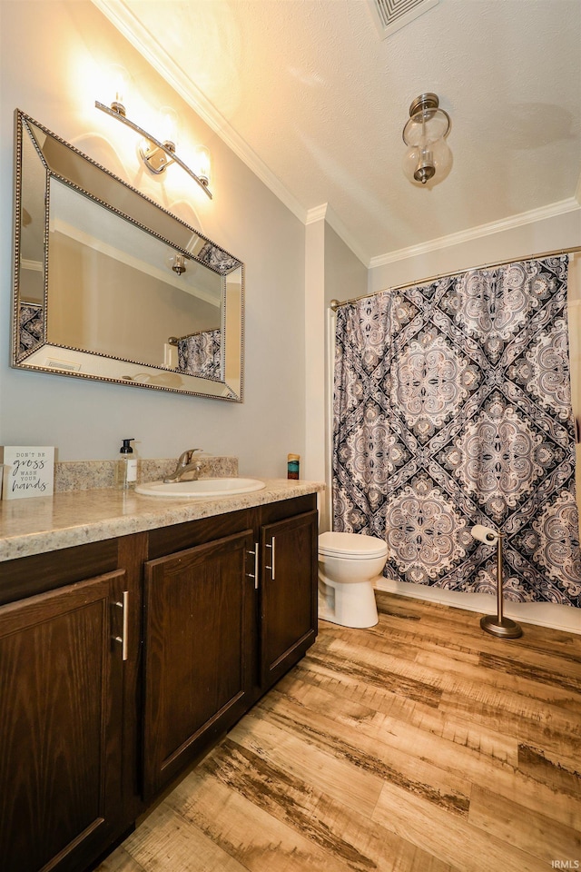 full bathroom with vanity, toilet, wood finished floors, and ornamental molding