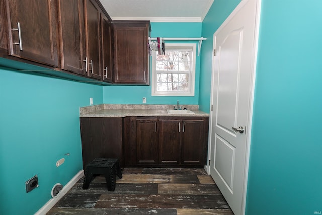 laundry area with dark wood-style floors, hookup for an electric dryer, cabinet space, a sink, and ornamental molding