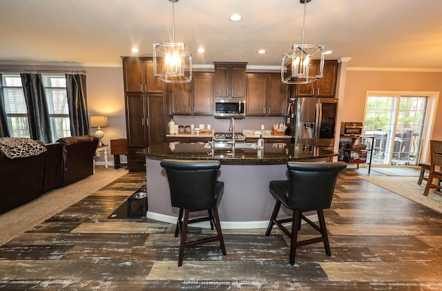 kitchen featuring a kitchen bar, plenty of natural light, appliances with stainless steel finishes, and crown molding