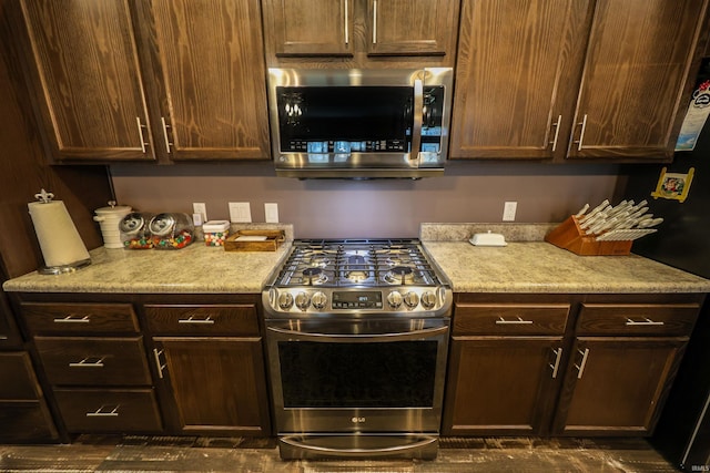 kitchen featuring dark brown cabinetry, appliances with stainless steel finishes, and light countertops