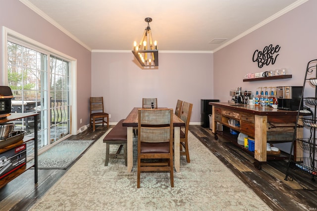 dining space featuring ornamental molding, baseboards, an inviting chandelier, and wood finished floors