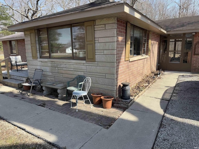 view of side of home with a patio and brick siding