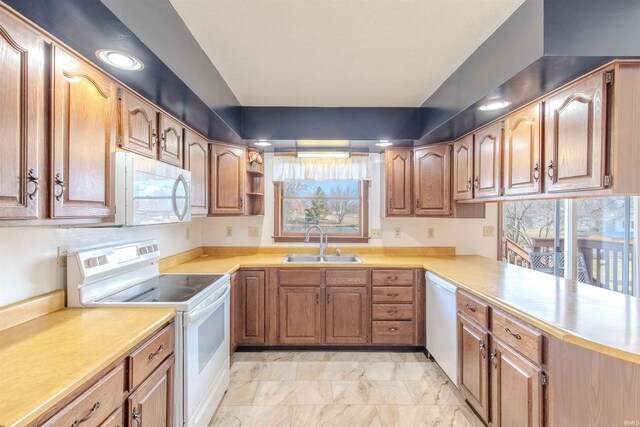 kitchen featuring a sink, white appliances, marble finish floor, and light countertops